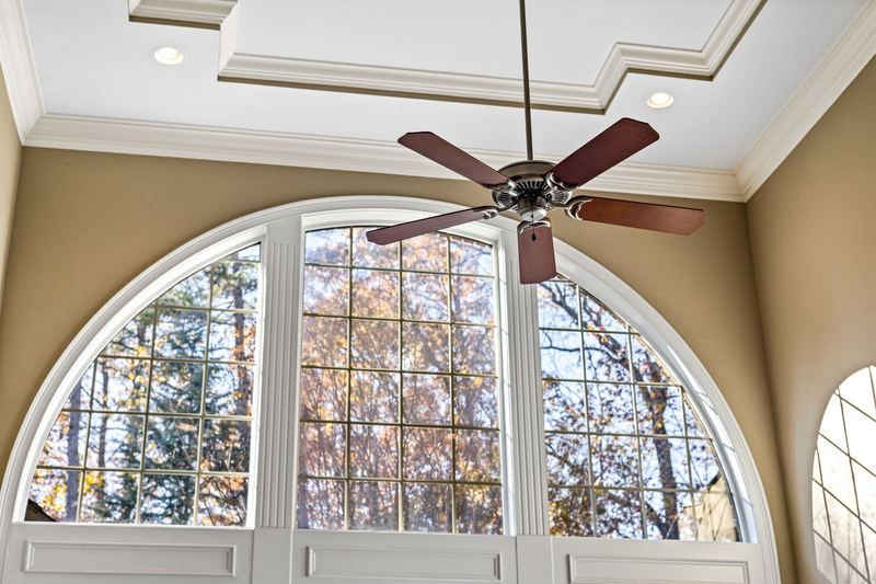Living room with a ceiling fan and arched window